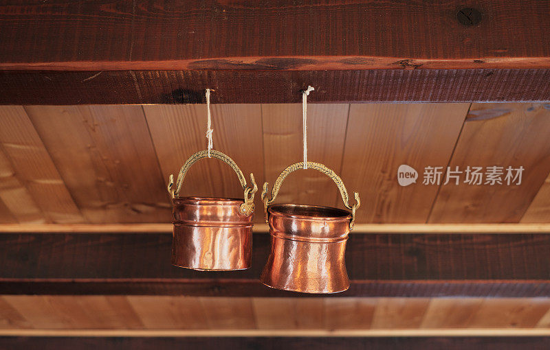 古朴的木墙上挂着几只铜锅