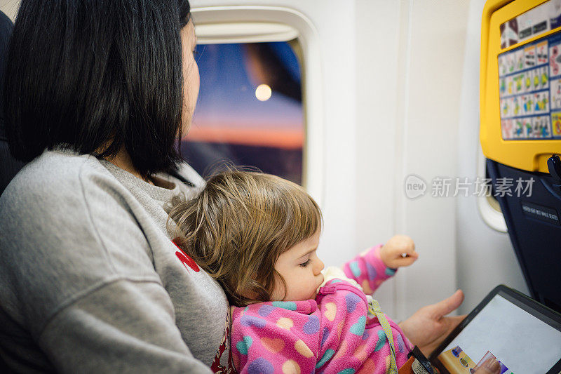 年轻的母亲和她的宝贝女儿乘飞机旅行。