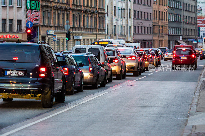 在交通堵塞的城市与汽车在道路上排在晚上和散景灯光-图像