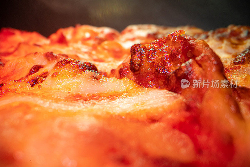 超近距离广角微距拍摄的美味热气腾腾的深盘辣香肠披萨新鲜出炉的烤箱在冷却架下的加热灯与复制空间