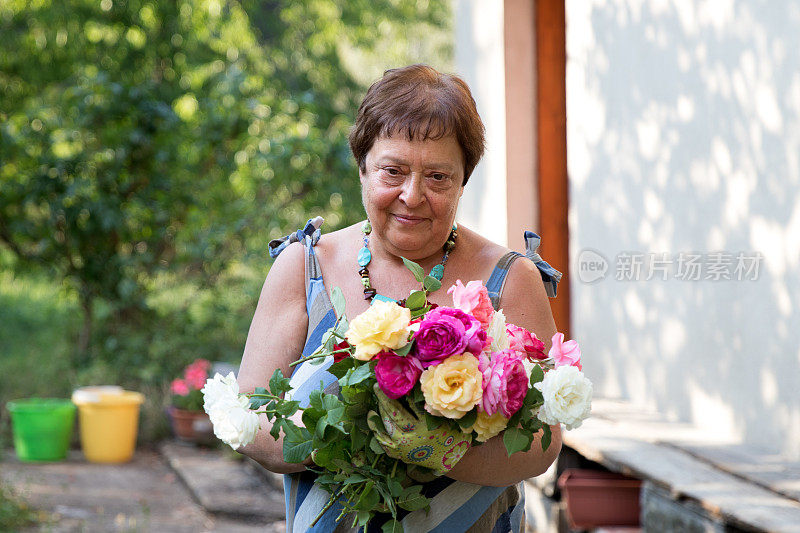 老年妇女以积极的心情在花园里练习周末休闲活动