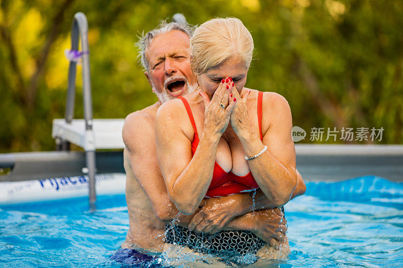 在游泳池度假的老年夫妇
