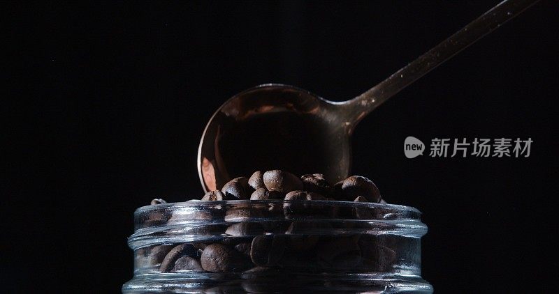 茶匙正从罐子里舀出咖啡豆。特写镜头