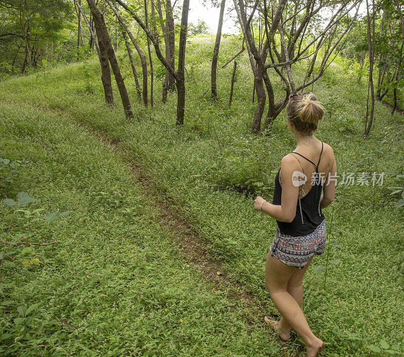 清晨，一名年轻女子走在森林小径上