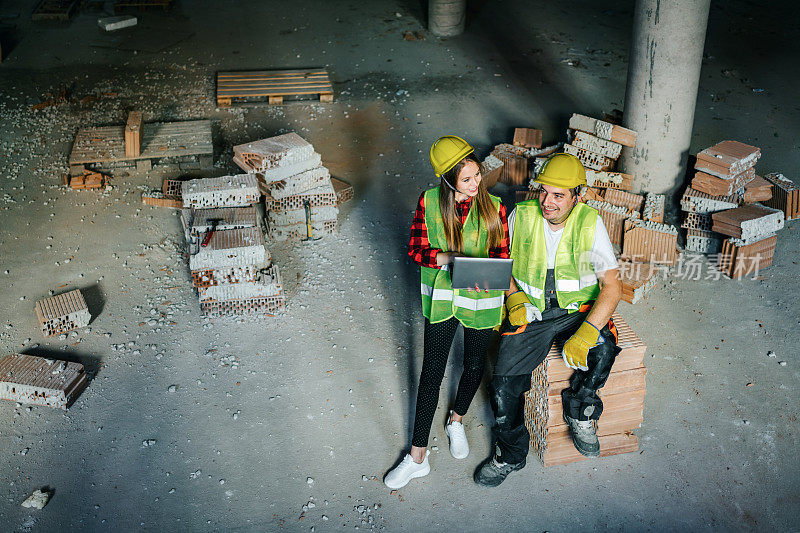 建筑师和建筑工人在建筑工地使用平板电脑