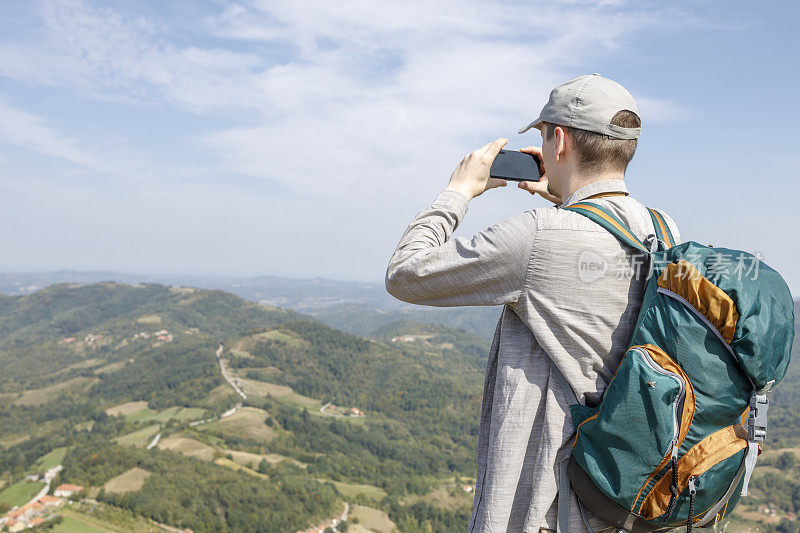 男人在徒步旅行时用手机拍照