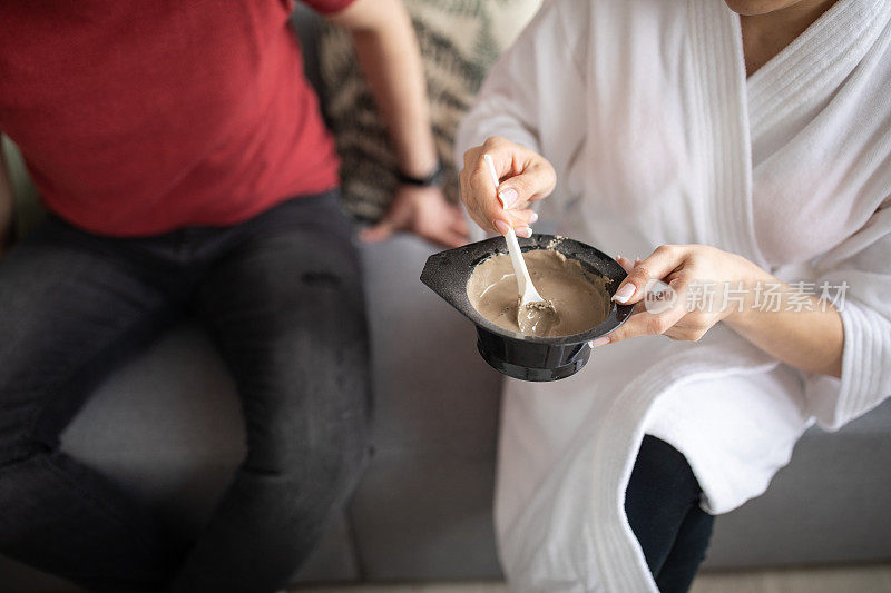 一名妇女在家中为她的美容护理准备粘土面膜