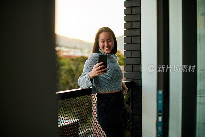 一个年轻女子站在自家阳台上的照片