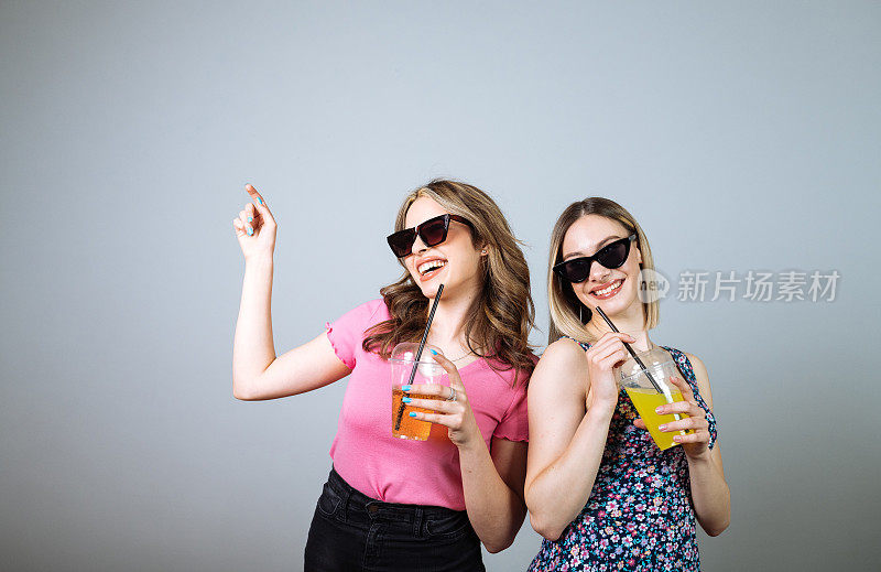 两个千禧一代的女人穿着夏装上了音乐会