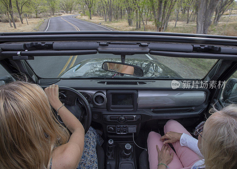 母女俩开着四轮驱动卡车在乡村公路上行驶