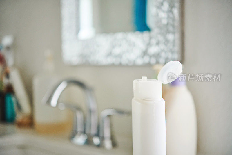 特写镜头的盖子的一个塑料瓶与开放的盖子在浴室设置