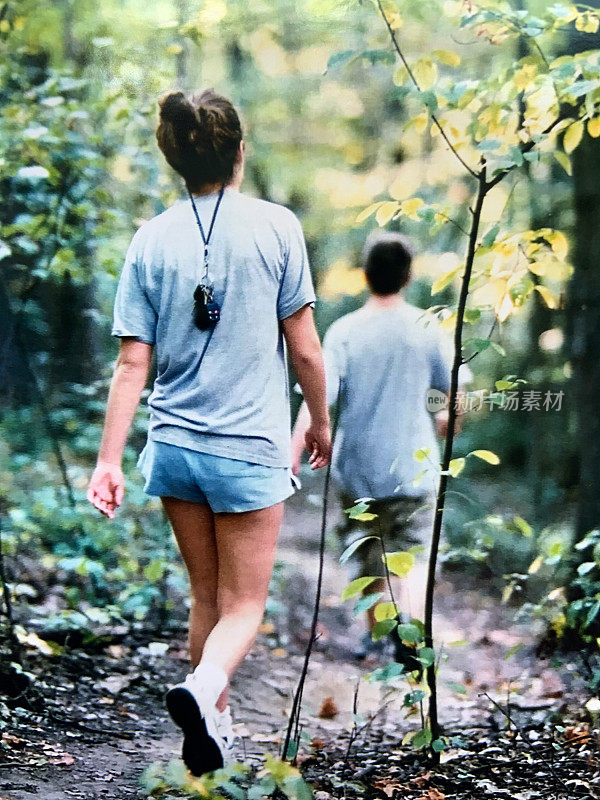 两个十几岁的孩子在树林里散步
