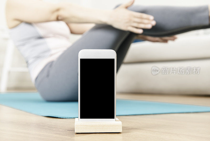用智能手机做瑜伽的女人