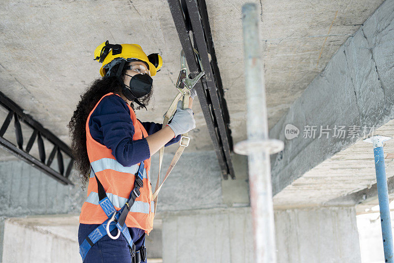 非洲羊毛妇女，建筑工人，使用所有的保护手段，同时作为一个工人