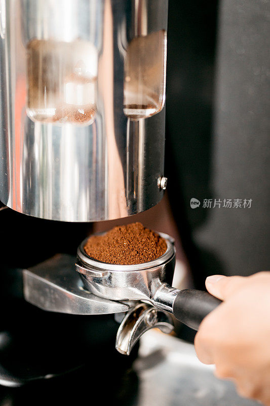 咖啡师从手动研磨机中研磨咖啡豆