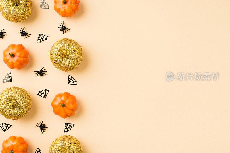 万圣节装饰蜘蛛网两排橙色和金色的小南瓜在孤立的米色背景与copyspace的顶部视图照片