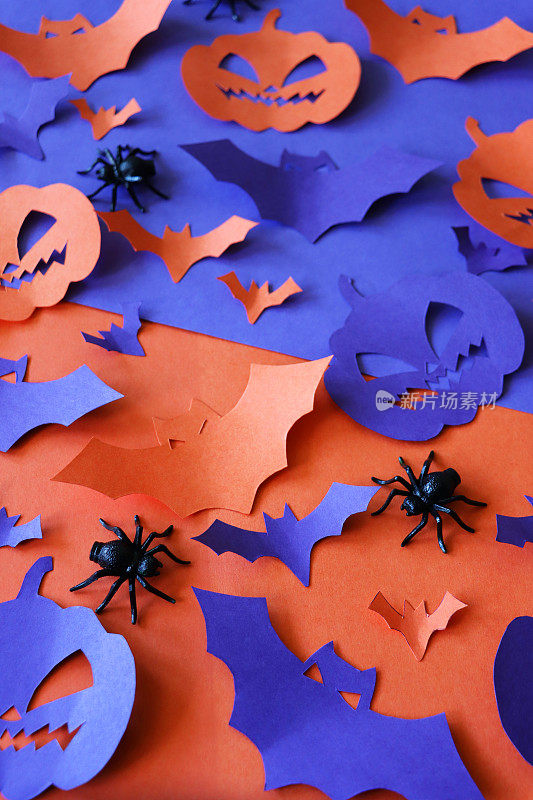 万圣节设计海报的形象，自制剪影形状的蝙蝠，南瓜杰克O'灯笼和塑料蜘蛛分裂紫色和橙色背景，万圣节墙纸背景