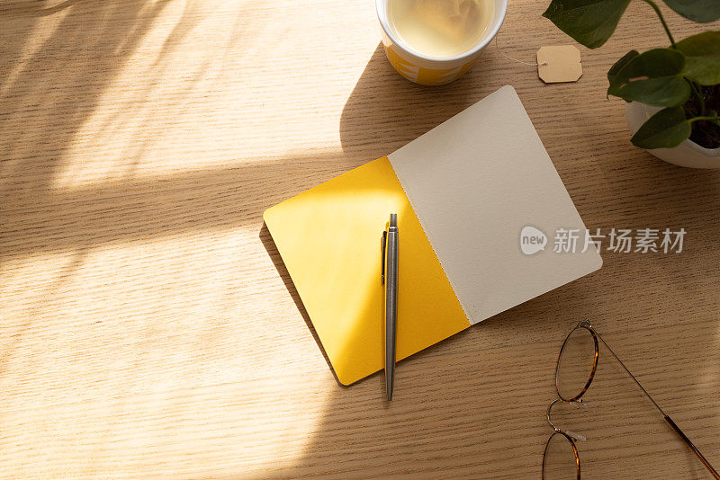 阳光明媚的桌上有黄页的笔记本