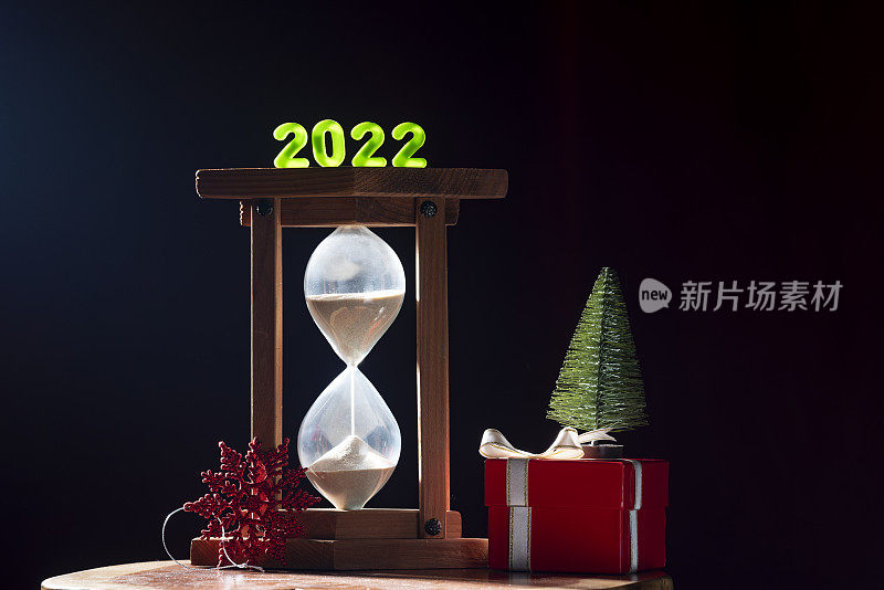 沙漏，礼盒和迷你圣诞树的照片与2022年新年数字