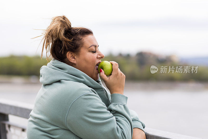 胖女人吃苹果的画像