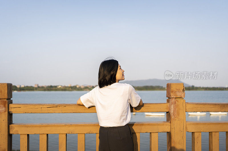 一位亚洲妇女在美丽的河边眺望远方