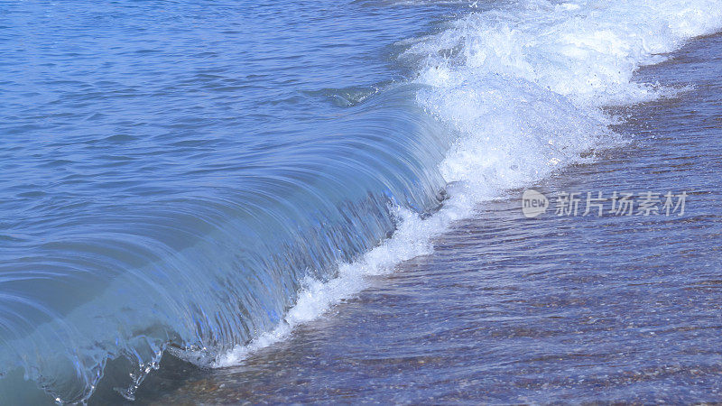 强大的海洋蓝色的海浪白色的泡沫。美丽的蓝色水背景。海浪汩汩作响。大海中的巨浪。不安分的水。动荡的大海。波涛汹涌的大海，波涛汹涌