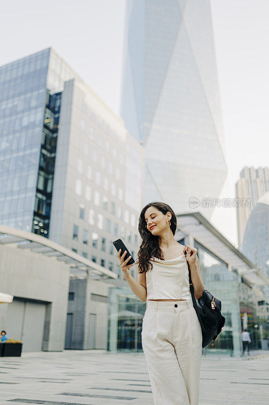 一个女人在街上用她的智能手机