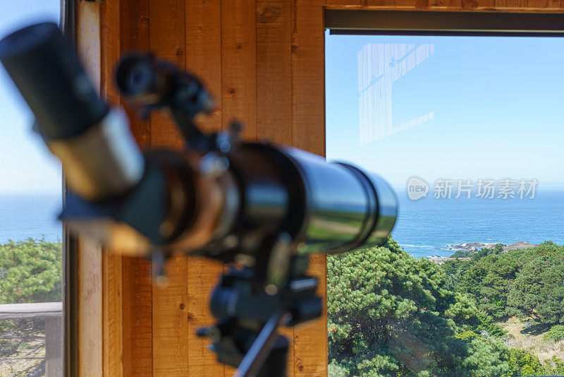 家里的望远镜靠窗户望向大海