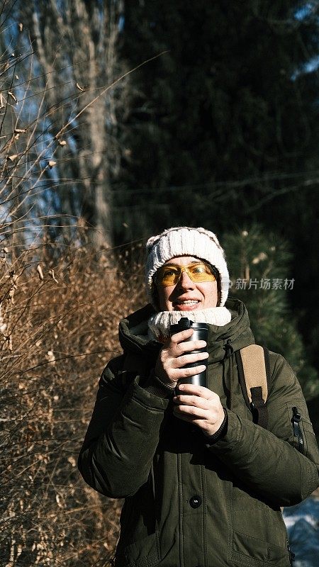 女游客正在用旅行杯喝热饮