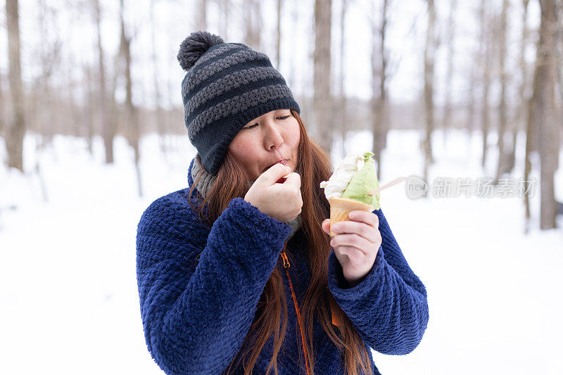 一名日本妇女在冬天吃抹茶和朗姆酒葡萄干冰淇淋