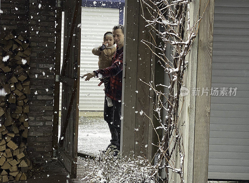 父亲带着蹒跚学步的儿子在雪地里离开