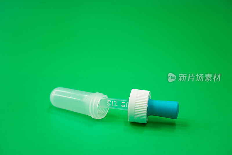 图像显示一个儿科解热滴管装置与剂量容积计与绿色背景上的帽子。