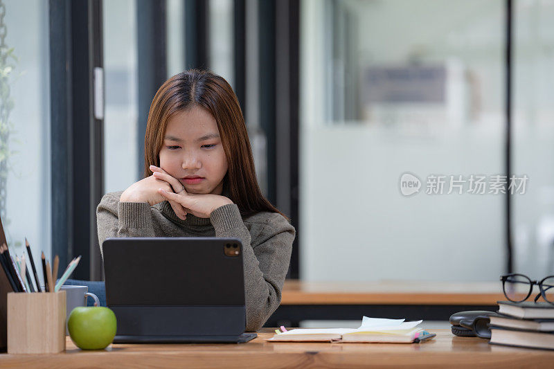 年轻的亚洲学生在大学图书馆读书和备考时承受着巨大的精神压力。亚洲学生看起来很紧张。
