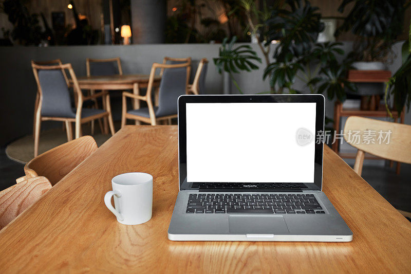 咖啡桌上的笔记本电脑屏幕是空白的