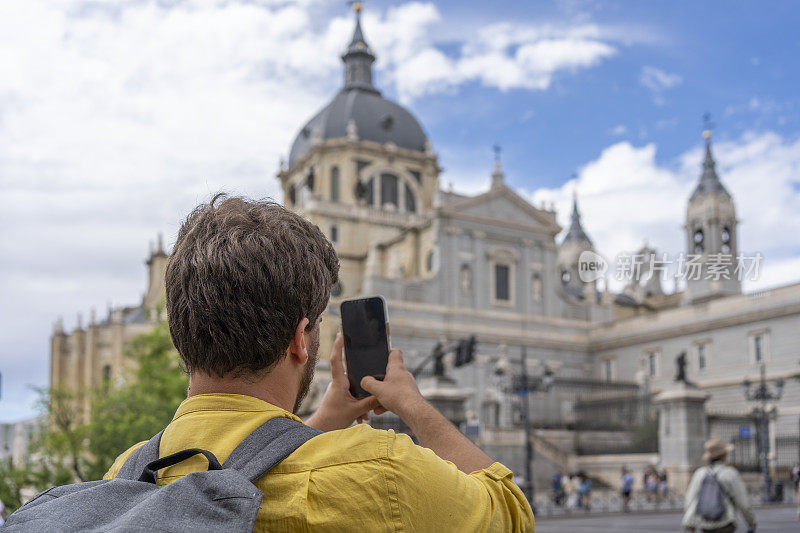 一名游客背着背包在西班牙马德里拍照。