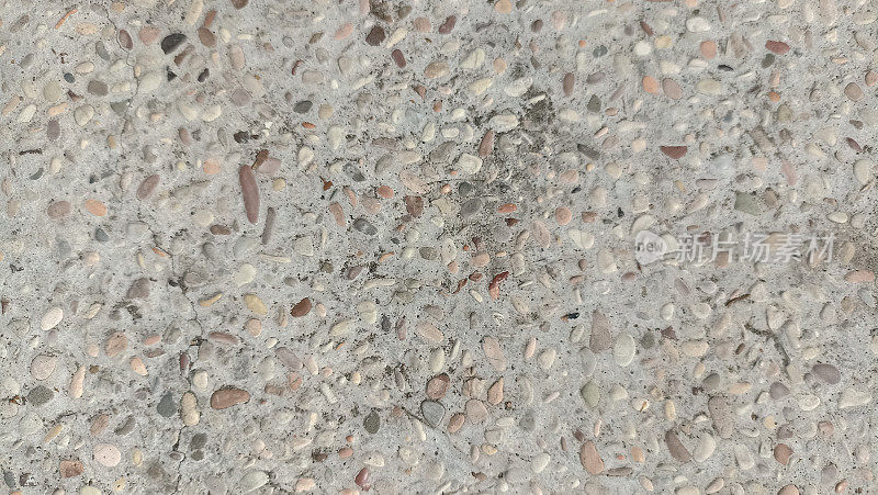 带有彩色砾石夹杂物的混凝土表面(墙)。磨碎的混凝土纹理与暴露的鹅卵石。带有花岗岩砾石内含物的混凝土未经抛光的表面图案。