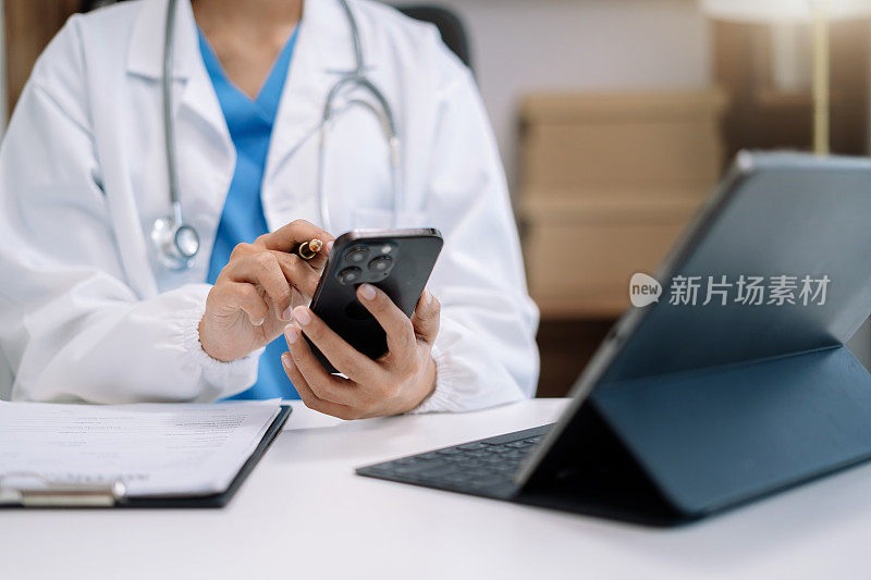 医生工作在数字智能手机和平板电脑保健医生技术平板电脑在现代办公室的办公桌上。