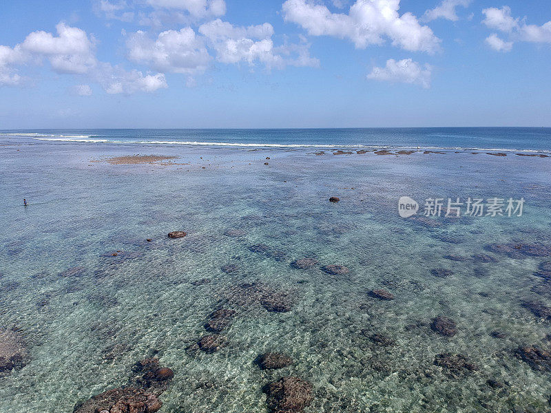 2023年8月，一个阳光明媚的日子，在退潮期间，无人机在巴厘岛乌鲁瓦图的宾金海滩拍摄的照片，周围有餐馆、房子和人们