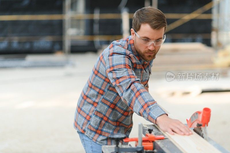 带电动圆锯的木材切割台。专业木工在锯木厂木工制造中统一切割木板。锯床