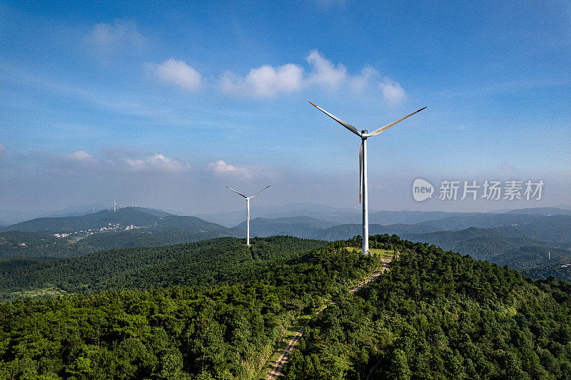 在晴朗的天气里，森林覆盖的山顶上的一组风力涡轮机