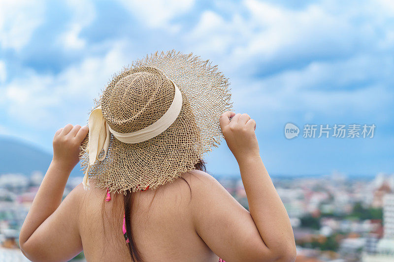 超重的年轻女子橙色swimsuitÂ和稻草沙滩太阳帽在游泳池放松快乐加上尺寸的女人身体积极假期旅行在夏天。