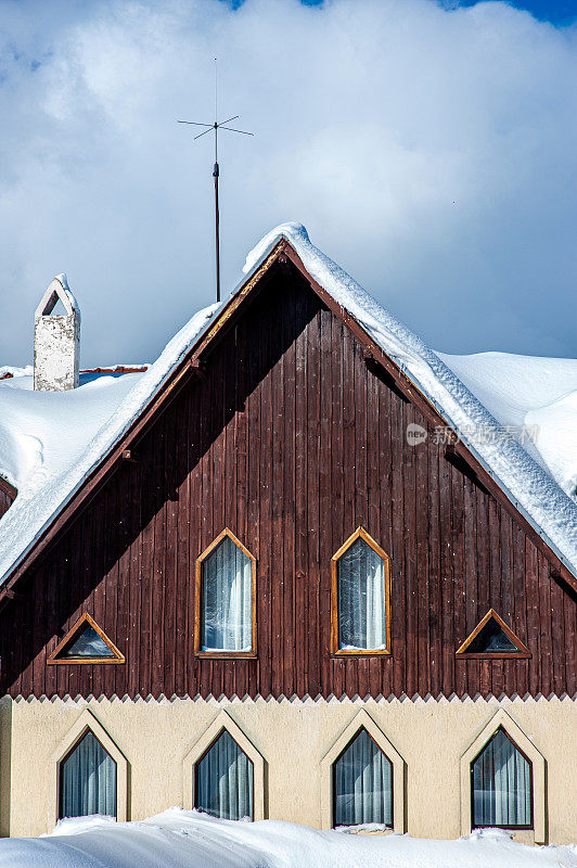 木质覆盖的建筑，尖屋顶和雪堆