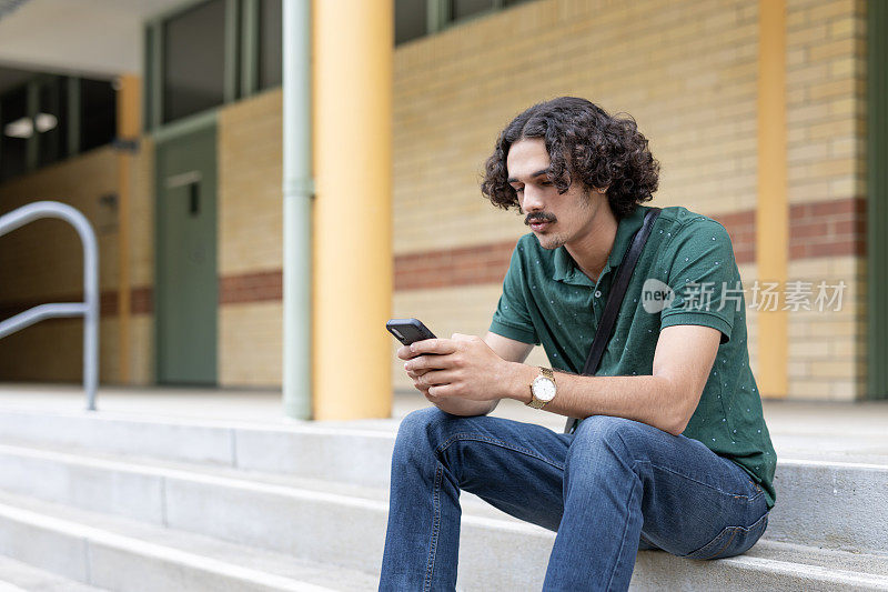 年轻的多种族男子在户外使用手机