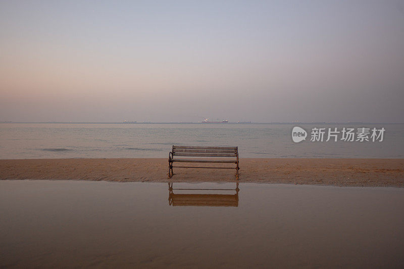 海滩上空荡荡的公园长椅。