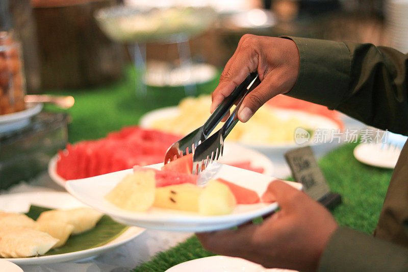 一名男子在餐厅拿食物的画像