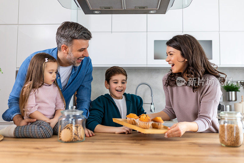 在厨房里，一家人一起享用纸杯蛋糕，一边尽情享受甜点，一边分享微笑和笑声。