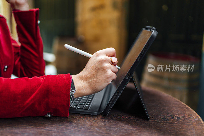 一名妇女正在用触控笔在数字平板电脑上工作
