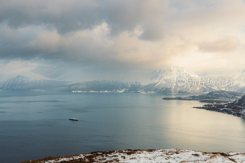 鸟瞰田园般的冬季景观，在挪威的渡轮穿越海洋和雪山山峰