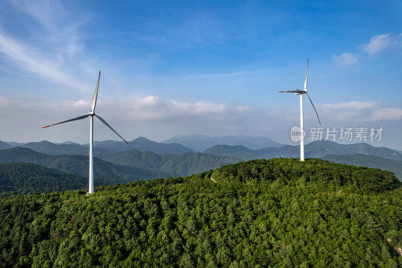 在阳光明媚的日子里，森林山上的风力涡轮机