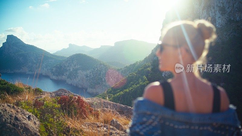 在山上徒步旅行的女游客。在炎热的暑假里享受美丽的风景